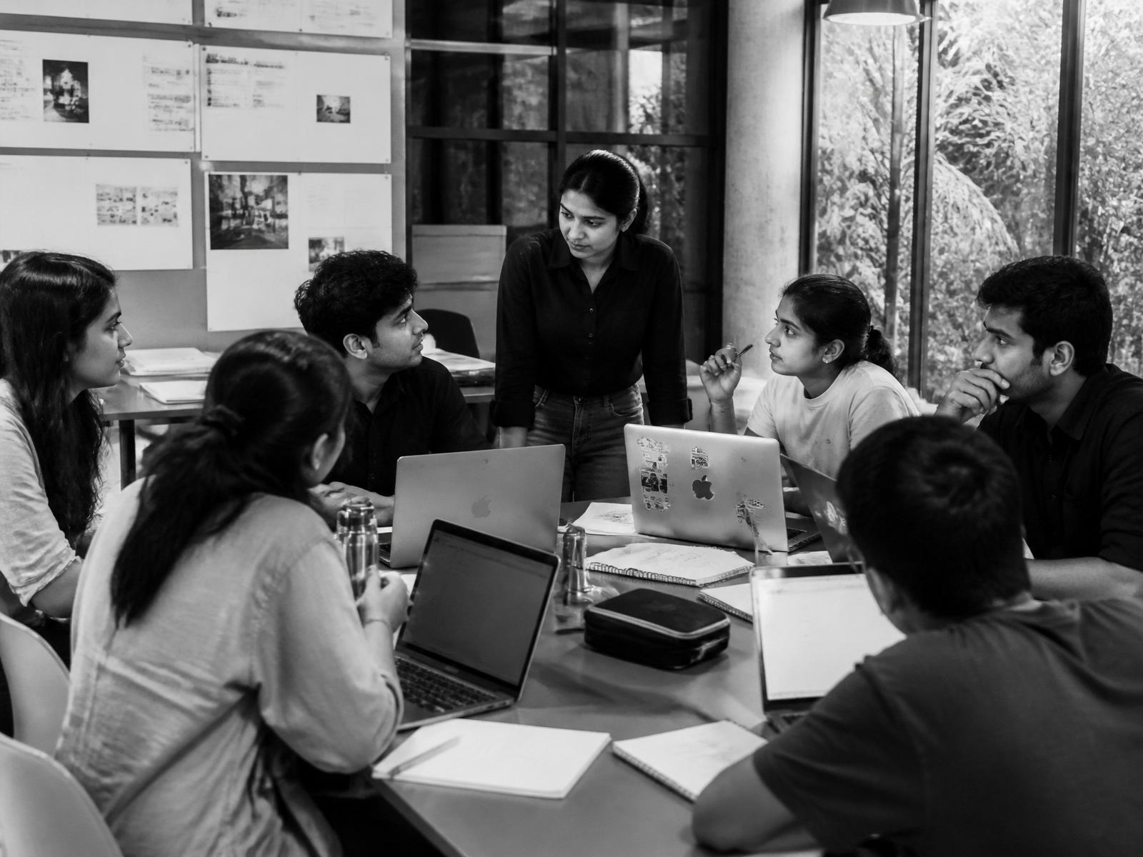 Indian students collaborating around a studio table